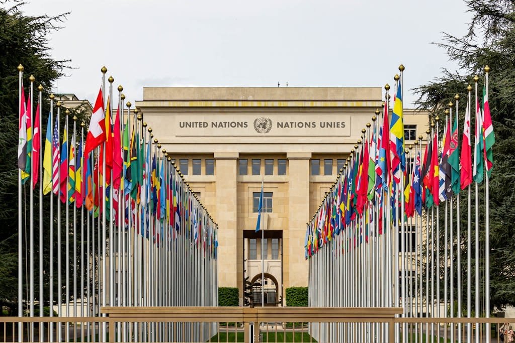 View of the United Nations Office in Geneva adorned with flags of various countries.