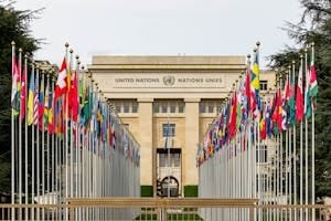 View of the United Nations Office in Geneva adorned with flags of various countries.