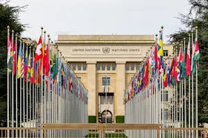 View of the United Nations Office in Geneva adorned with flags of various countries.