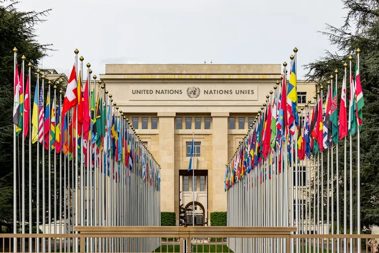 View of the United Nations Office in Geneva adorned with flags of various countries.